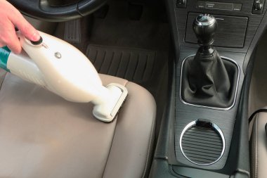 Yakın çekim-arabada temizlik. Bir elektrikli süpürge ile çalışma ve temizlik makine içinde yeşil bezi. Otomatik iç hakkında bakım. Ticari temizlik şirketi. 