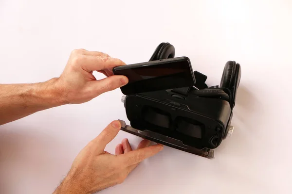 Руки вставляють смартфон для окулярів віртуальної реальності (VR ) — стокове фото
