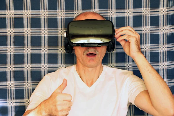 Hombre en gafas de realidad virtual, fondo a cuadros azul —  Fotos de Stock