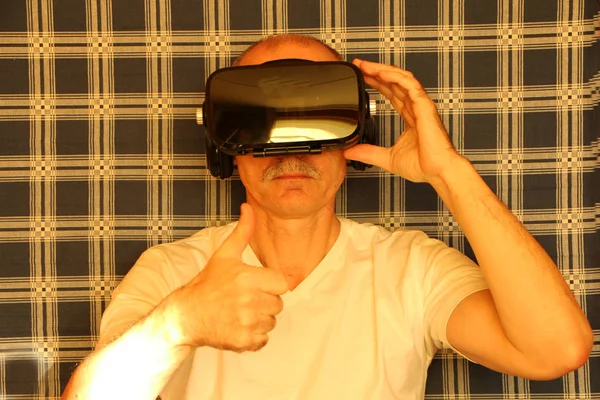 Homem de óculos de realidade virtual, fundo xadrez azul — Fotografia de Stock