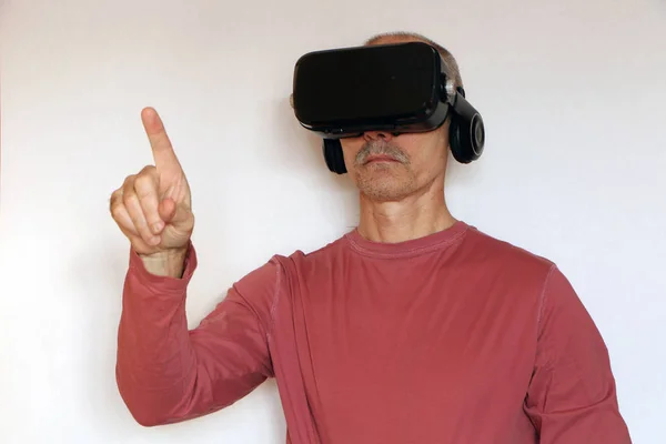 Close-up de um homem em uma camiseta rosa com óculos de real virtual — Fotografia de Stock