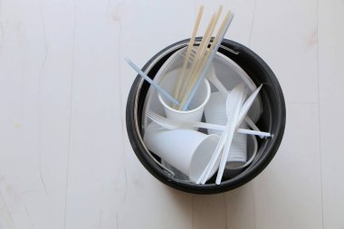 Çöp kutusunda tek kullanımlık plastik yemekler.
