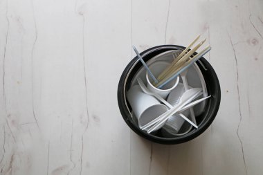 Çöp kutusunda tek kullanımlık plastik yemekler.
