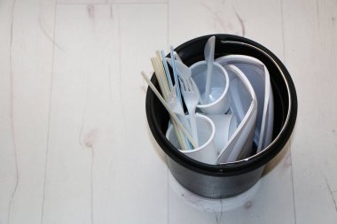 Çöp kutusunda tek kullanımlık plastik yemekler.