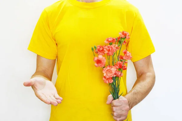 Крупный план - мужчина держит гвоздичные цветы в руке и растягивает — стоковое фото