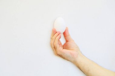  White dietary egg in hand on white background. clipart