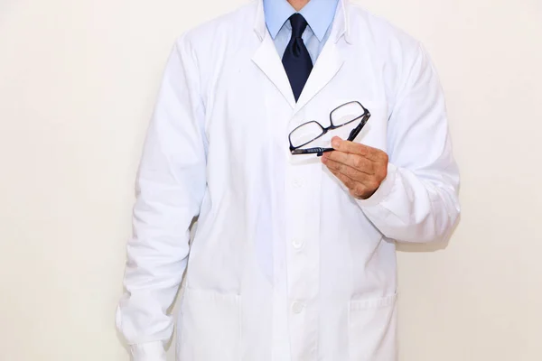 Optometrista de abrigo blanco con gafas en la mano — Foto de Stock