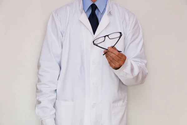 Optometrista in mantello bianco con gli occhiali in mano — Foto Stock