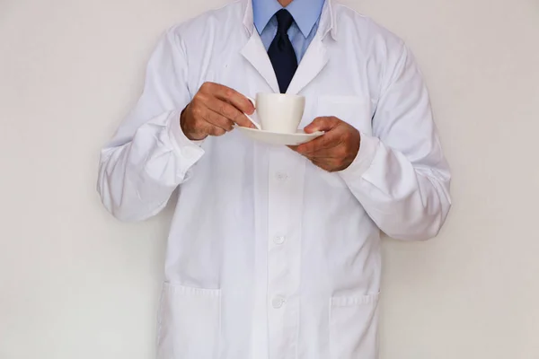 Nahaufnahme - der Arzt hält eine Tasse Kaffee in der Hand — Stockfoto