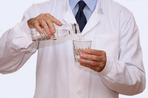 Close-up - Doutor derrama água mineral em um copo — Fotografia de Stock