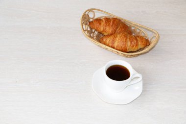 Yakın çekim - kahvaltı, bir fincan kahve ve kruvasan.