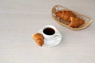 Yakın çekim - kahvaltı, bir fincan kahve ve kruvasan.