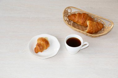Yakın çekim - kahvaltı, bir fincan kahve ve kruvasan.