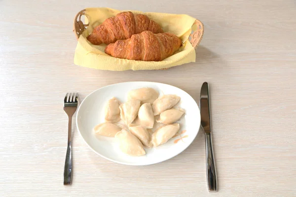 Sur la table il y a des boulettes dans une assiette et une fourchette . — Photo