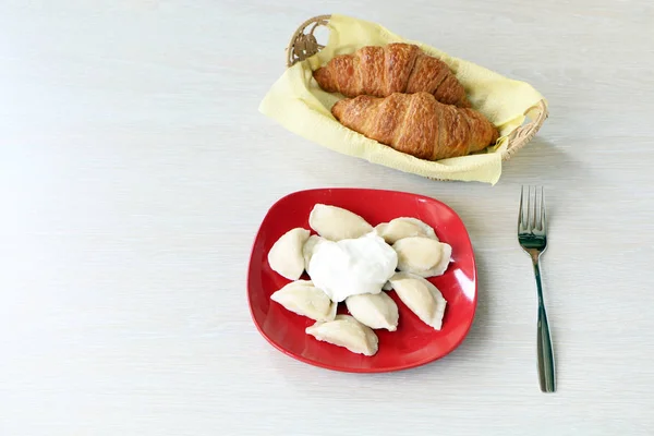 Sur la table il y a des boulettes dans une assiette et une fourchette . — Photo