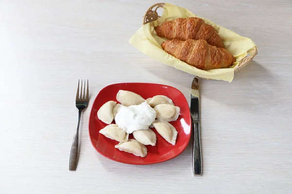 Sur la table il y a des boulettes dans une assiette et une fourchette . — Photo