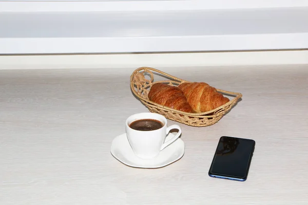 Petit déjeuner avec croissant, café et téléphone — Photo