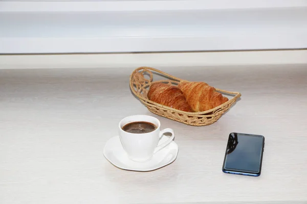 Petit déjeuner avec croissant, café et téléphone — Photo