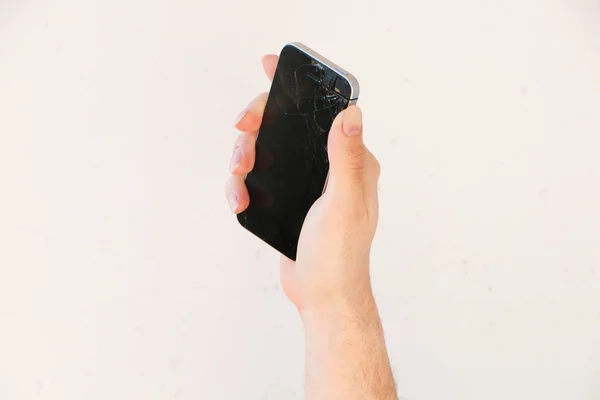 若い男の手にスマートフォンの画面の壊れたガラス 白い背景 — ストック写真