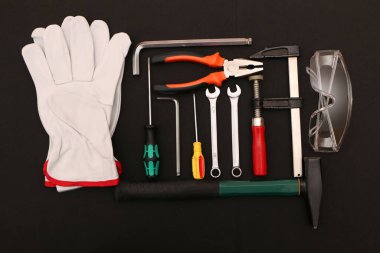 Siyah arka planda yeni el aletleri, maske, gözlük ve eldivenler. Siyah arka planda güvenli bir iş için yeni el aletleri ve koruyucu ekipmanlar..