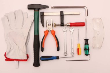 Beyaz arka planda yeni el aletleri, maske, gözlük ve eldivenler. Beyaz arka planda güvenli bir operasyon için yeni el aletleri ve koruyucu ekipmanlar..