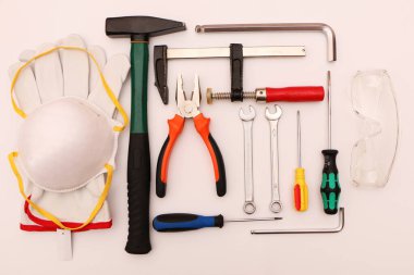 Beyaz arka planda yeni el aletleri, maske, gözlük ve eldivenler. Beyaz arka planda güvenli bir operasyon için yeni el aletleri ve koruyucu ekipmanlar..