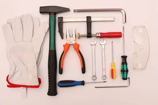 A set of new hand tools, mask, glasses and gloves on a white background. A set of new hand tools and protective equipment for safe operation on a white background.
