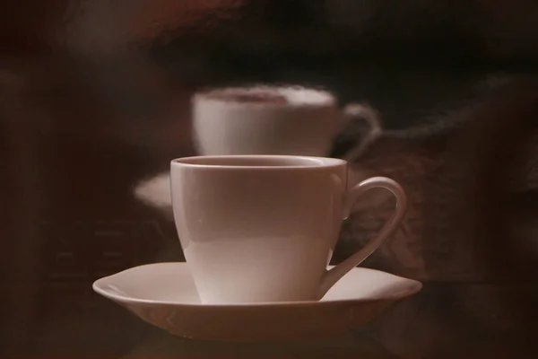 ガラスのテーブルの上にコーヒーとホワイトカップ ミラー3D反射 透明感のある背景に隔離された白いリアルなコーヒーカップ — ストック写真