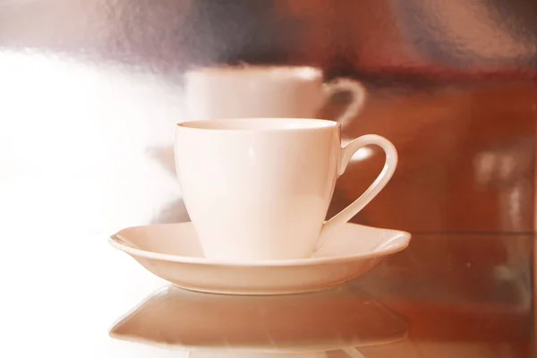 White cup with coffee on a glass table. Background - mirror 3D reflection. White realistic coffee cup  isolated on transparent background.
