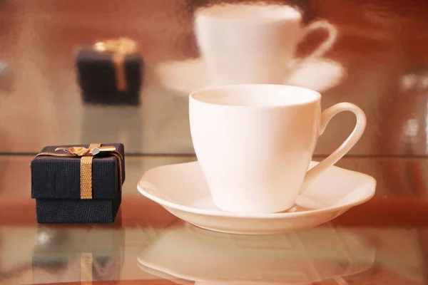 Белая Чашка Кофе Стеклянном Столе Рядом Ней Украшенная Коробка Подарком — стоковое фото