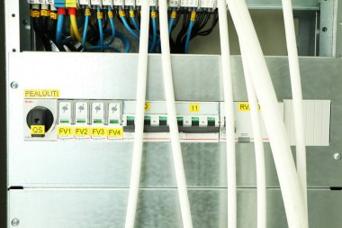 İnşaat halindeki bir binada kablolar olan açık bir elektrik paneli..