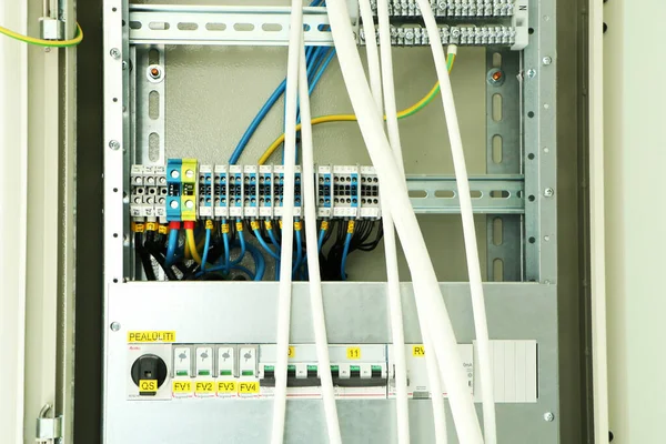 İnşaat halindeki bir binada kablolar olan açık bir elektrik paneli..