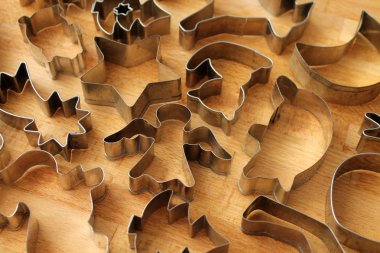 Ahşap arka plan üzerinde farklı çerez formları. Kurabiye pişirme için metal kalıplar.