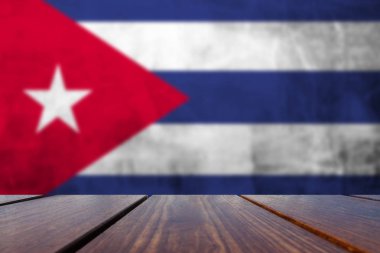 Wood Table Top Background and Grunge flag of Cuba on concrete wall. clipart