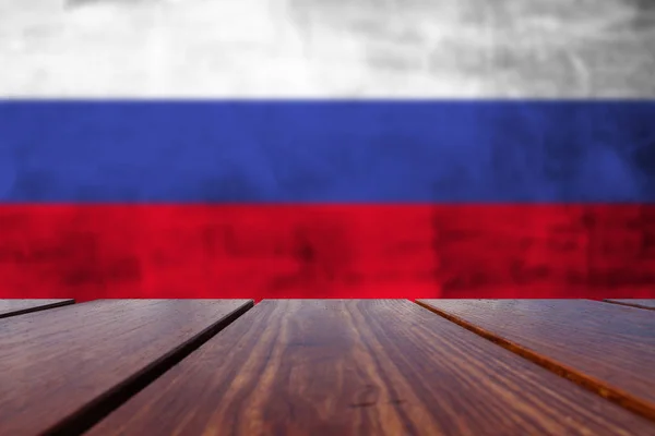 木製テーブル トップ背景とグランジのコンクリート壁にロシア国旗 — ストック写真