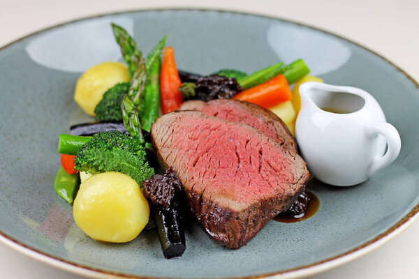 Beef steak with steamed vegetables close up.