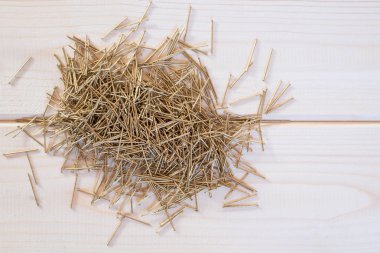 Doğal ışık ile ahşap arka plan üzerinde Pirinç çivi. Altın karanfiller ahşap tahtalar üzerinde yalan