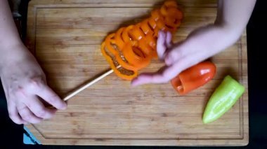 Olgun yüzük dolmalık biber yatıyordu çıkmadan deseni ve rastgele renkli bir bıçak ile kesmek