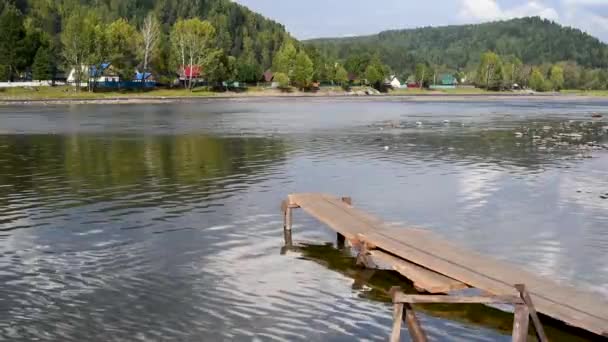 老桥在河上的小船停泊在夏天反对村庄的绿色在距离 — 图库视频影像