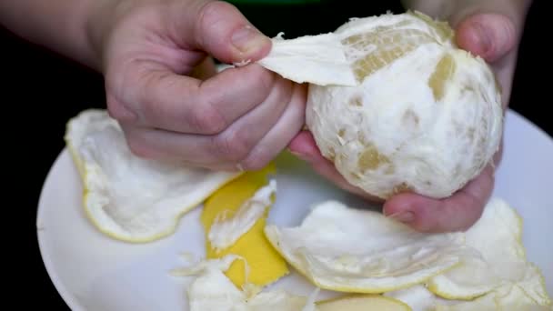 把手放在白色盘子上的白色多汁柚子剥皮 — 图库视频影像