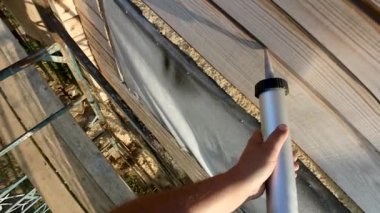 Mühürleme eklem ve çatlaklar silikon dolgu macunu ve izolasyon, izolasyon, boya, boya ve metal bir ağaç yükseklikte dolgu macunu bir şırınga yükseklikte ahşap bir ev boyama 