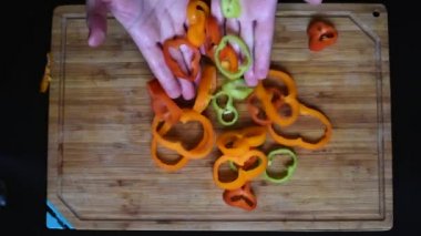 Olgun yüzük dolmalık biber yatıyordu çıkmadan deseni ve rastgele renkli bir bıçak ile kesmek 