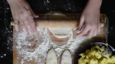 Yemyeşil hamur. Patates ve soğan ve dereotu bir ahşap tahta veya karanlık bir tabak turta yaparım Hamur Mayaları dışarı rulo