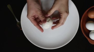 Tavuk yumurtası evde yumurta kabuğunun ellerini farklı renkleri beyaz ve kahverengi siyah bir tablo üzerinde beyaz bir tabakta yumurta yumurta kabuğu kaldırmak.