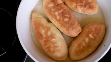 Lezzetli ev yapımı yemyeşil turta dolguları beyaz bir Pan sıcak bitkisel yağ içinde çeşitli fry. Bitkisel yağ içinde beyaz bir pan börek kızarmış 