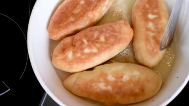Lezzetli ev yapımı yemyeşil turta dolguları beyaz bir Pan sıcak bitkisel yağ içinde çeşitli fry. Bitkisel yağ içinde beyaz bir pan börek kızarmış 