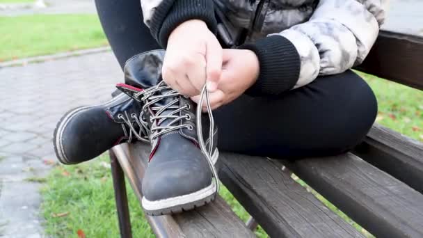 Dětské Vázání Tkaničky Černé Kožené Boty Zatímco Sedí Lavičce Ulici — Stock video