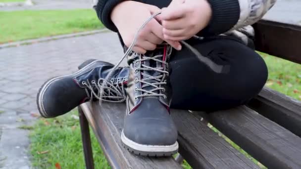 Dětské Vázání Tkaničky Černé Kožené Boty Zatímco Sedí Lavičce Ulici — Stock video