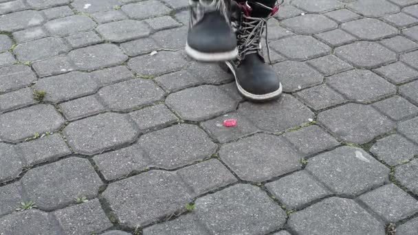 孩子踩踏糖果脚 穿着靴子 在街道的人行道上 玩食物 — 图库视频影像