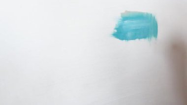 Düz fırçalar ile tuval üzerinde mavi yağlı boya ile beyaz bir tuval üzerine resim olan sanatçı boyalar çeşitli vuruş uygulanan. Yakın çekim çekim 